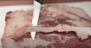 Removing fat from beef.